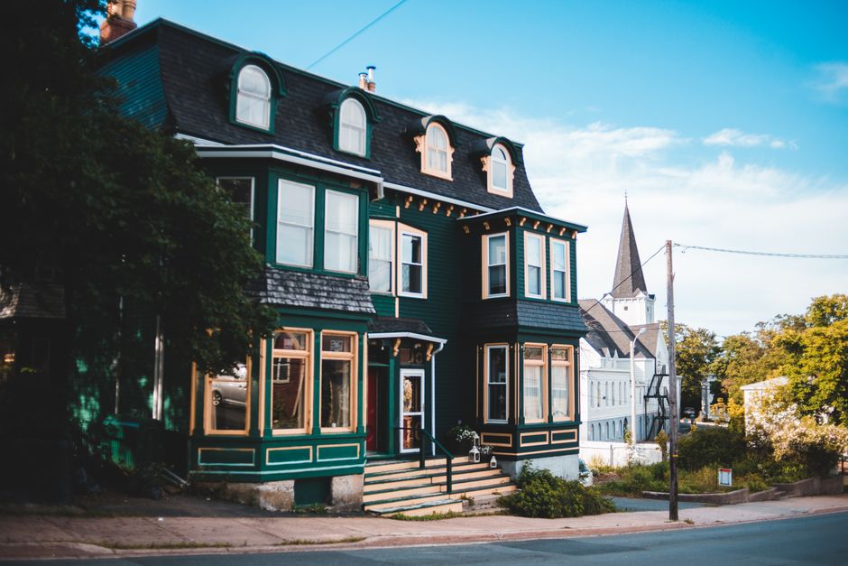 Bright, sunny residential street lined with charming traditional homes in Louisville, Kentucky, setting the scene for a lo...