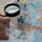 Professional person stands looking at a large wall map with various locations, symbolizing strategic analysis of different...